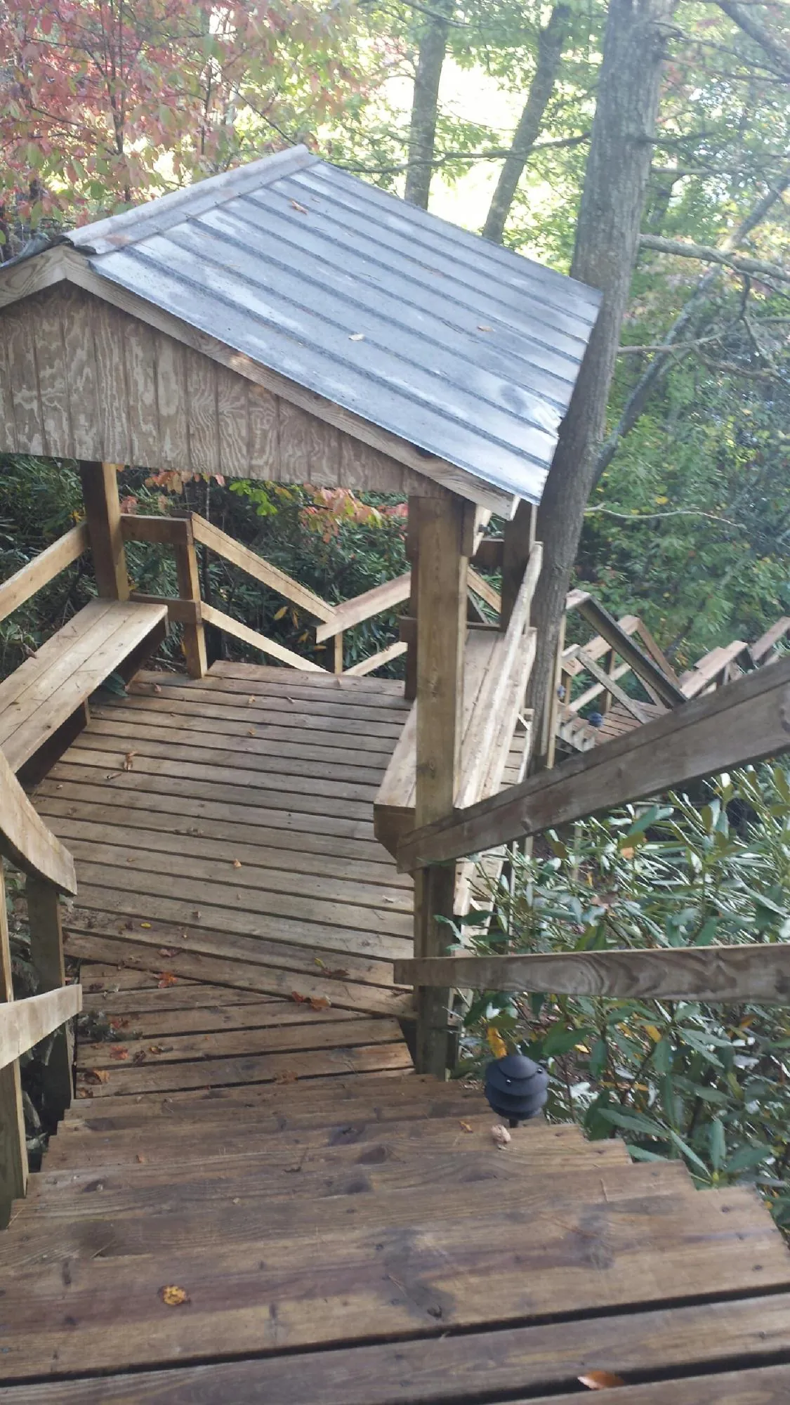 Metal roofed shelter over wooden steps on a wooded walkway — Skylight Repair & Installation work by our crew in Shamokin Dam